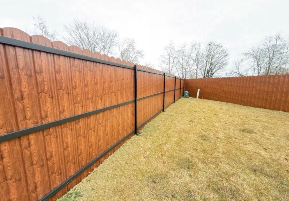 Wood-look steel privacy fence wrapping a backyard
